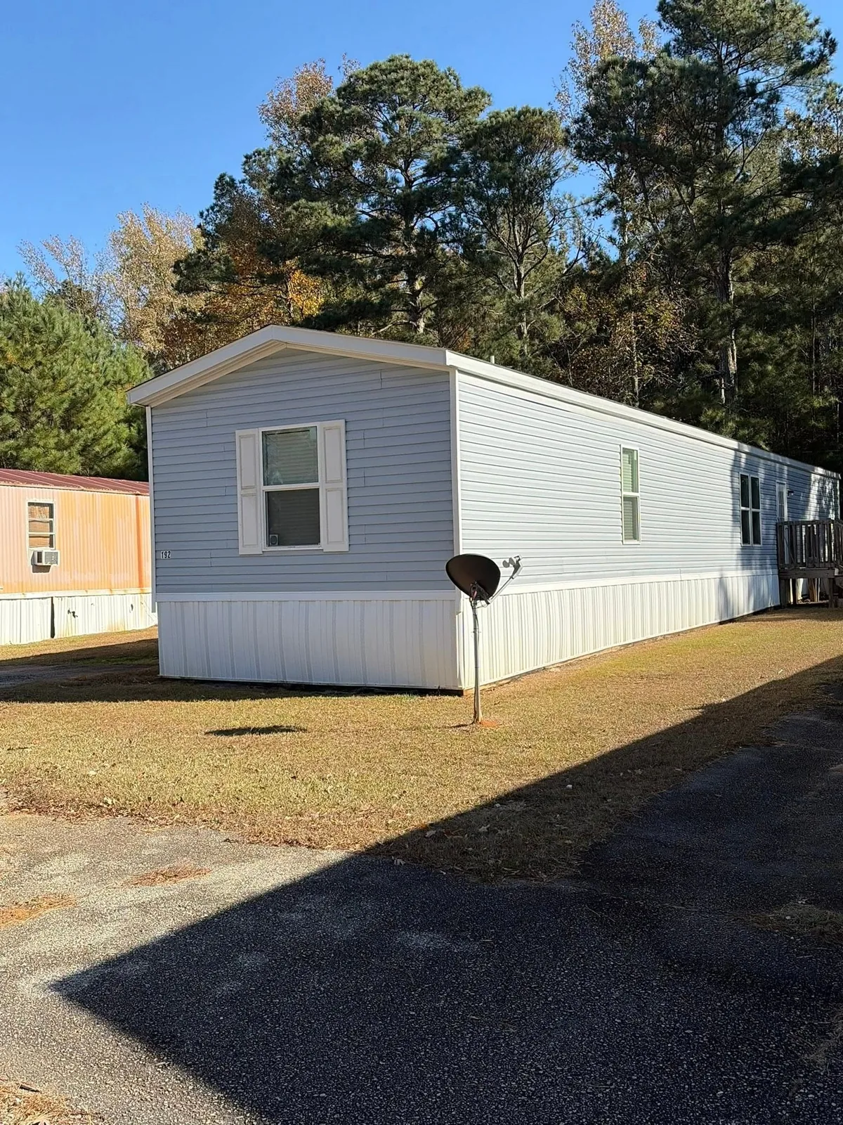 Maintained residential property and driveway beside a manufactured home